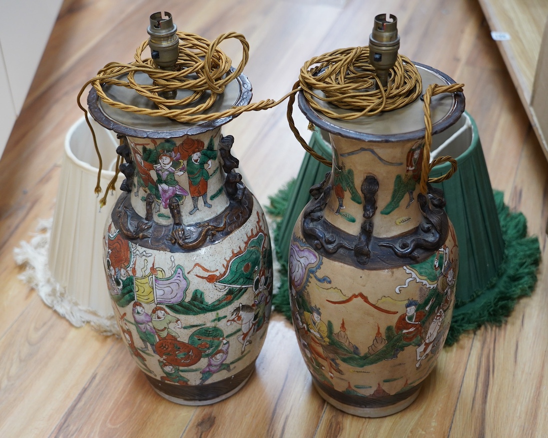 A pair of early 20th century Chinese famille verte crackle glaze ‘warrior’ vases converted to lamps with shades, height 44cm. Condition - fair to good